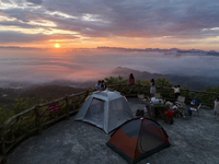 Tourists are watching the sunrise from a viewing platform over the Three Gorges in Yichang, China, on July 7, 2024. (