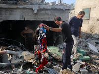 Palestinians are assessing the damage following an Israeli strike in Al-Zawayda in the central Gaza Strip on July 7, 2024, amid the ongoing...