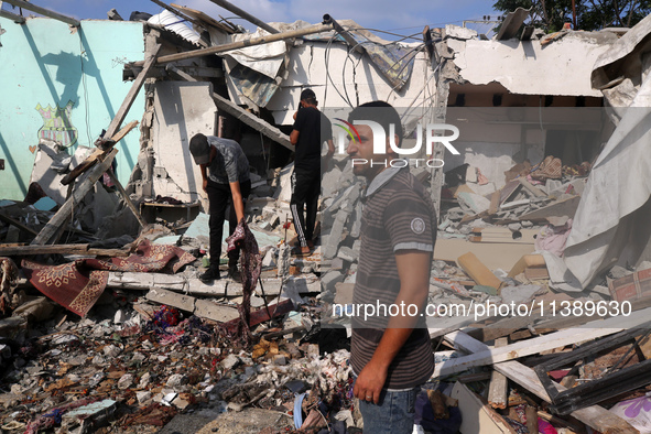 Palestinians are assessing the damage following an Israeli strike in Al-Zawayda in the central Gaza Strip on July 7, 2024, amid the ongoing...