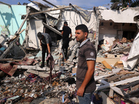 Palestinians are assessing the damage following an Israeli strike in Al-Zawayda in the central Gaza Strip on July 7, 2024, amid the ongoing...