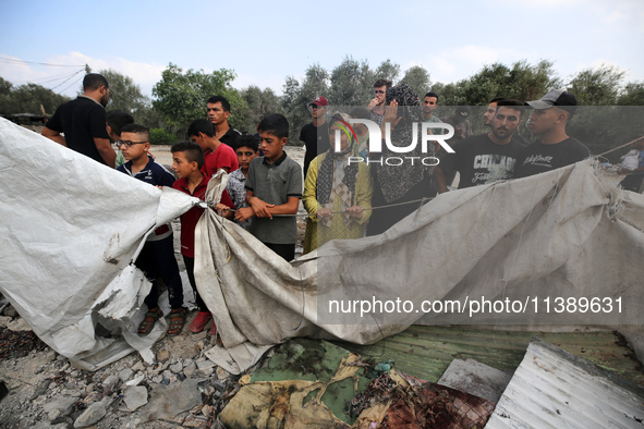 Palestinians are assessing the damage following an Israeli strike in Al-Zawayda in the central Gaza Strip on July 7, 2024, amid the ongoing...