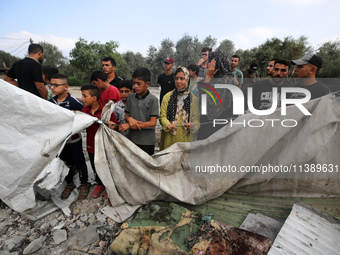 Palestinians are assessing the damage following an Israeli strike in Al-Zawayda in the central Gaza Strip on July 7, 2024, amid the ongoing...