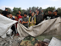 Palestinians are assessing the damage following an Israeli strike in Al-Zawayda in the central Gaza Strip on July 7, 2024, amid the ongoing...