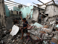 Palestinians are assessing the damage following an Israeli strike in Al-Zawayda in the central Gaza Strip on July 7, 2024, amid the ongoing...