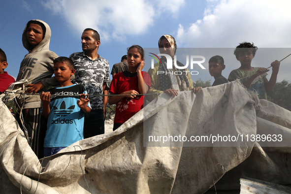 Palestinians are assessing the damage following an Israeli strike in Al-Zawayda in the central Gaza Strip on July 7, 2024, amid the ongoing...