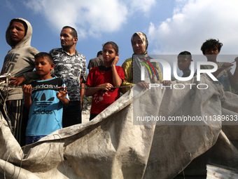 Palestinians are assessing the damage following an Israeli strike in Al-Zawayda in the central Gaza Strip on July 7, 2024, amid the ongoing...