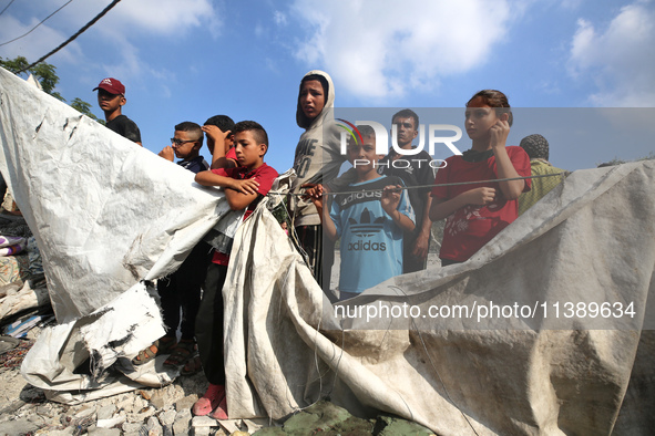 Palestinians are assessing the damage following an Israeli strike in Al-Zawayda in the central Gaza Strip on July 7, 2024, amid the ongoing...