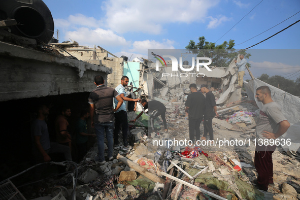 Palestinians are assessing the damage following an Israeli strike in Al-Zawayda in the central Gaza Strip on July 7, 2024, amid the ongoing...