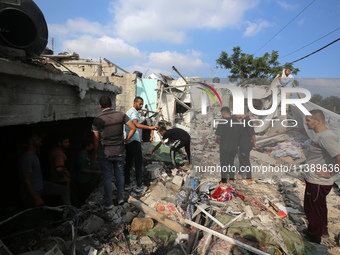 Palestinians are assessing the damage following an Israeli strike in Al-Zawayda in the central Gaza Strip on July 7, 2024, amid the ongoing...