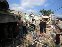 Palestinians are assessing the damage following an Israeli strike in Al-Zawayda in the central Gaza Strip on July 7, 2024, amid the ongoing...