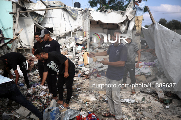 Palestinians are assessing the damage following an Israeli strike in Al-Zawayda in the central Gaza Strip on July 7, 2024, amid the ongoing...