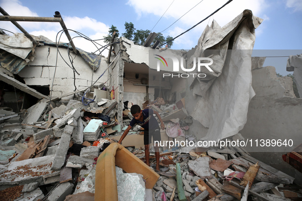 A Palestinian boy is checking the rubble of a residential building destroyed in an Israeli strike in Al-Zawayda in the central Gaza Strip on...