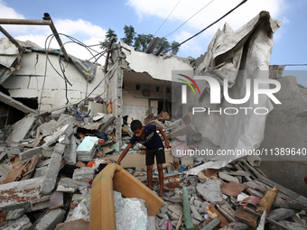 A Palestinian boy is checking the rubble of a residential building destroyed in an Israeli strike in Al-Zawayda in the central Gaza Strip on...