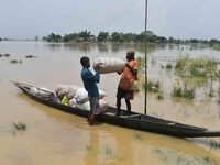 Villagers are shifting liquefied sacks of rice to a safer place in Nagaon District of Assam, India, on July 7, 2024. (