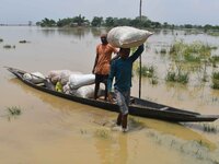 Villagers are shifting liquefied sacks of rice to a safer place in Nagaon District of Assam, India, on July 7, 2024. (