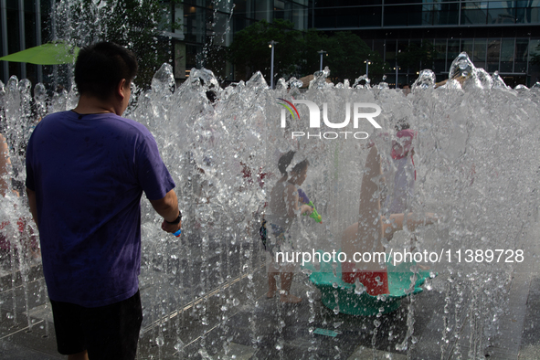 Kids are playing in water and keeping cool in Shanghai, China, on July 7, 2024. 