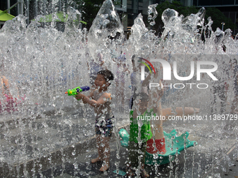 Kids are playing in water and keeping cool in Shanghai, China, on July 7, 2024. (