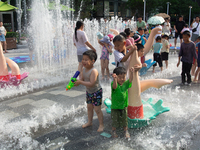 Kids are playing in water and keeping cool in Shanghai, China, on July 7, 2024. (