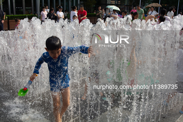 Kids are playing in water and keeping cool in Shanghai, China, on July 7, 2024. 