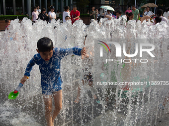 Kids are playing in water and keeping cool in Shanghai, China, on July 7, 2024. (