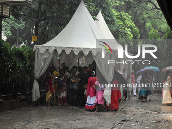 People are taking shelter during a heavy rain in Kolkata, India, on July 7, 2024. (