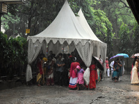 People are taking shelter during a heavy rain in Kolkata, India, on July 7, 2024. (