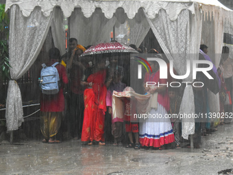 People are taking shelter during a heavy rain in Kolkata, India, on July 7, 2024. (