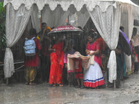 People are taking shelter during a heavy rain in Kolkata, India, on July 7, 2024. (