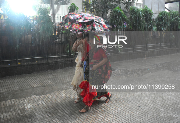 Women are passing during heavy rain in Kolkata, India, on July 7, 2024. 