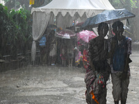 People are walking during heavy rain in Kolkata, India, on July 7, 2024. (