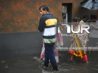 People are walking on the waterlogged street due to heavy rain in Kolkata, India, on July 7, 2024. (