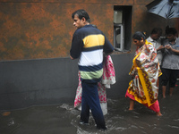 People are walking on the waterlogged street due to heavy rain in Kolkata, India, on July 7, 2024. (