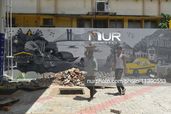 Laborers are working inside a constructed petrol pump in Kolkata, India, on July 7, 2024. 