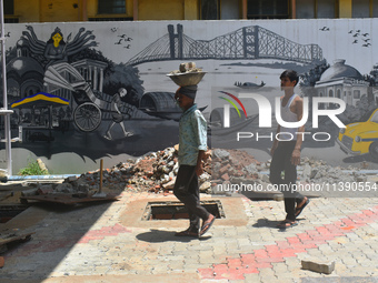 Laborers are working inside a constructed petrol pump in Kolkata, India, on July 7, 2024. (