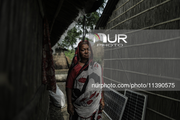 A woman is standing at a stranger's house as she is taking shelter after her house is washed away by flood water in Kurigram, Bangladesh, on...