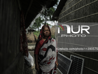 A woman is standing at a stranger's house as she is taking shelter after her house is washed away by flood water in Kurigram, Bangladesh, on...