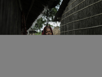 A woman is standing at a stranger's house as she is taking shelter after her house is washed away by flood water in Kurigram, Bangladesh, on...