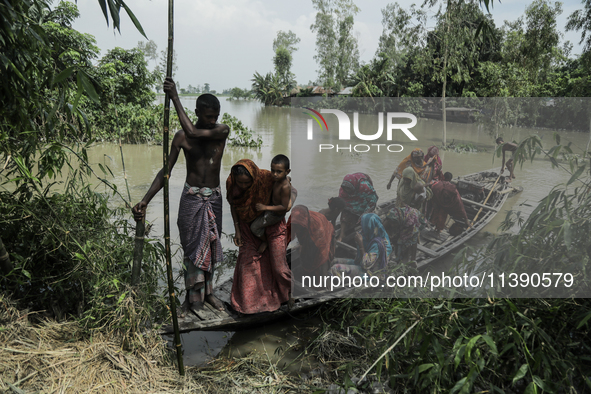 People are migrating locally to high land as their homes are being submerged by flood water in Kurigram, Bangladesh, on July 7, 2024. 