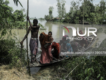 People are migrating locally to high land as their homes are being submerged by flood water in Kurigram, Bangladesh, on July 7, 2024. (