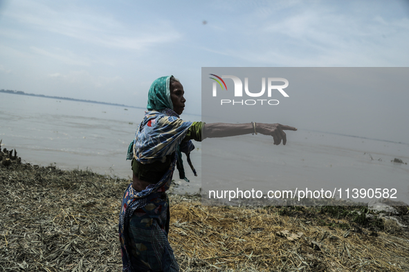 A woman is showing her house washed away by flood water in Kurigram, Bangladesh, on July 7, 2024. 