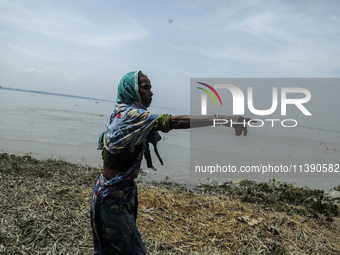 A woman is showing her house washed away by flood water in Kurigram, Bangladesh, on July 7, 2024. (