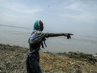 A woman is showing her house washed away by flood water in Kurigram, Bangladesh, on July 7, 2024. (