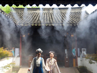 Visitors are playing in a lingering garden installed with spray in Suzhou, Jiangsu province, China, on July 8, 2024. In the hot summer, the...