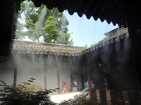 Visitors are playing in a lingering garden installed with spray in Suzhou, Jiangsu province, China, on July 8, 2024. In the hot summer, the...