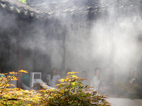 Visitors are playing in a lingering garden installed with spray in Suzhou, Jiangsu province, China, on July 8, 2024. In the hot summer, the...