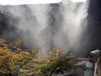 Visitors are playing in a lingering garden installed with spray in Suzhou, Jiangsu province, China, on July 8, 2024. In the hot summer, the...