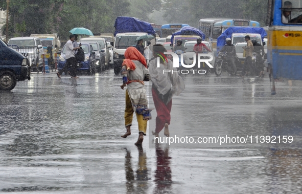 Commuters are walking past during rainfall in Kolkata, India, on July 08, 2024. 