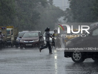 Commuters are walking past during rainfall in Kolkata, India, on July 08, 2024. (