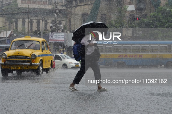 Commuters are walking past during rainfall in Kolkata, India, on July 08, 2024. 