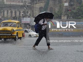 Commuters are walking past during rainfall in Kolkata, India, on July 08, 2024. (